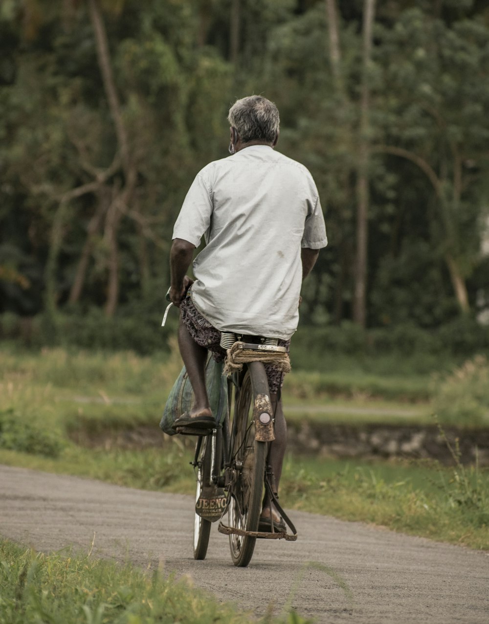 a man riding a bike down a dirt road