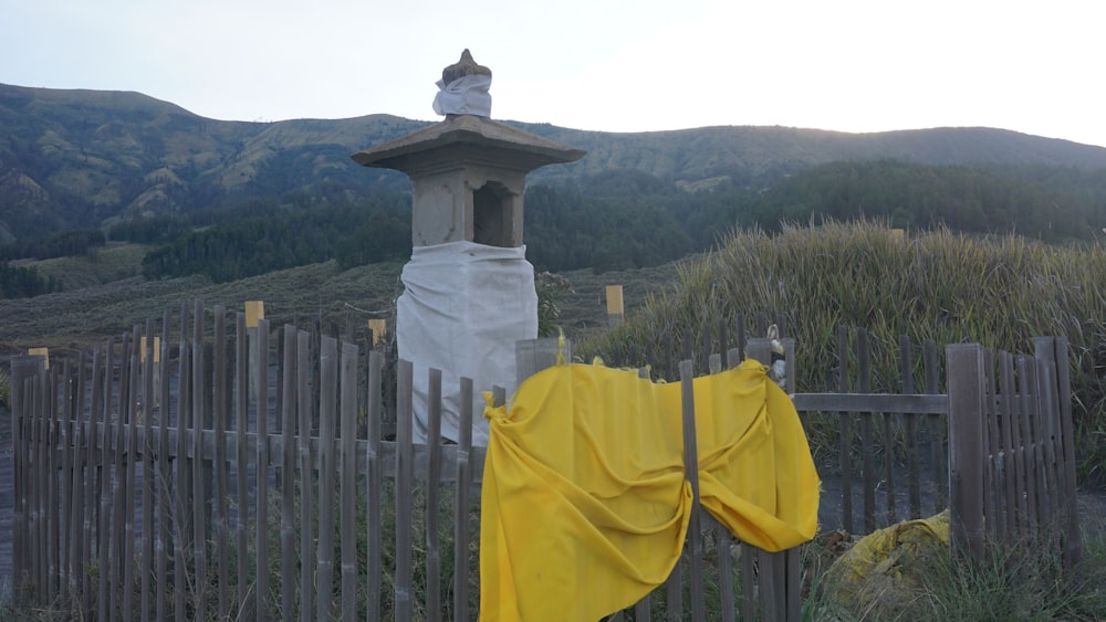a yellow cloth is hanging on a fence