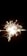 Bright sparkler emitting radiant sparks against a dark background, creating a starburst effect.