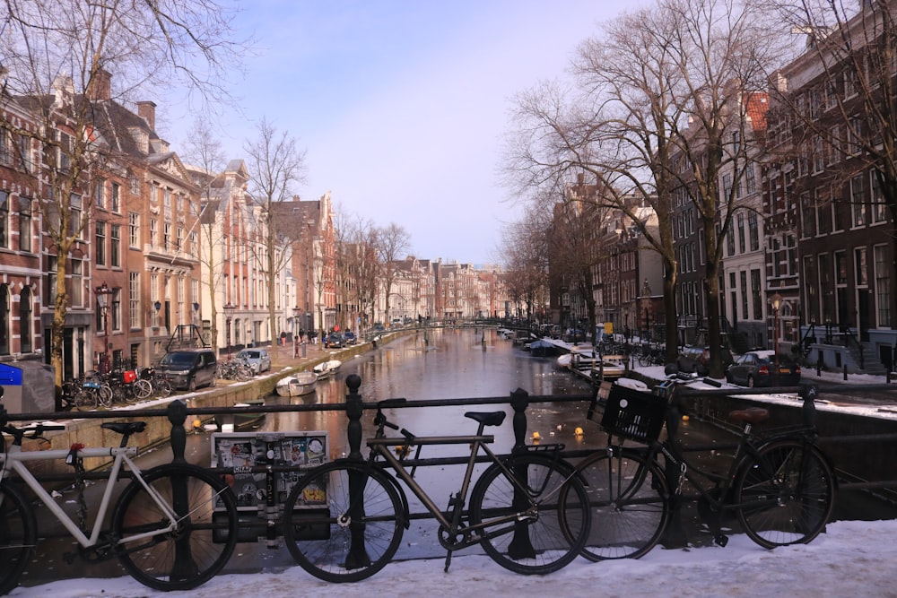 a row of bikes parked next to each other on a snow covered street