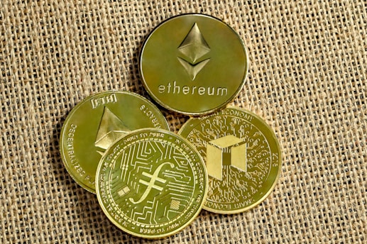 three gold coins with a bitcoin on top of them