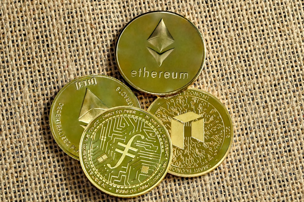 Trois pièces d’or avec un bitcoin au-dessus d’eux
