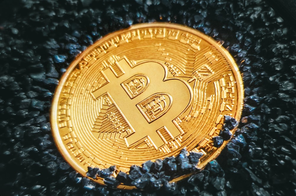 Ein Bitcoin, der auf einem Haufen schwarzer Steine sitzt