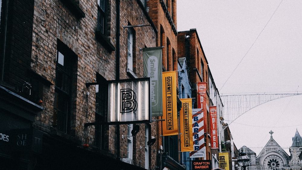 a row of buildings with signs hanging from the side of them