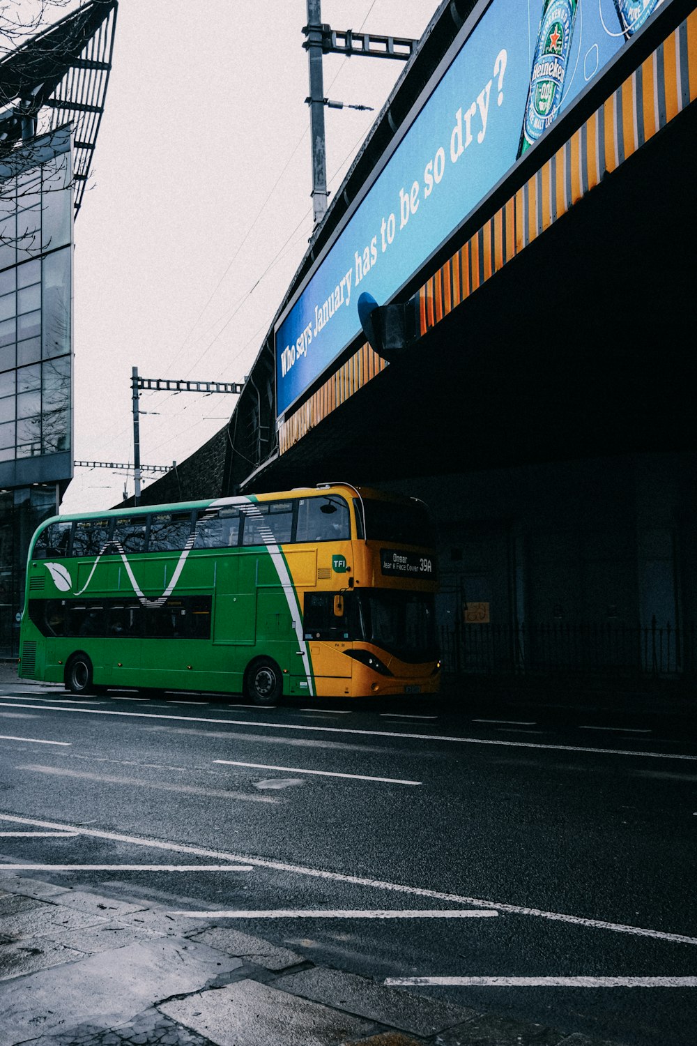 a green and yellow bus parked on the side of the road