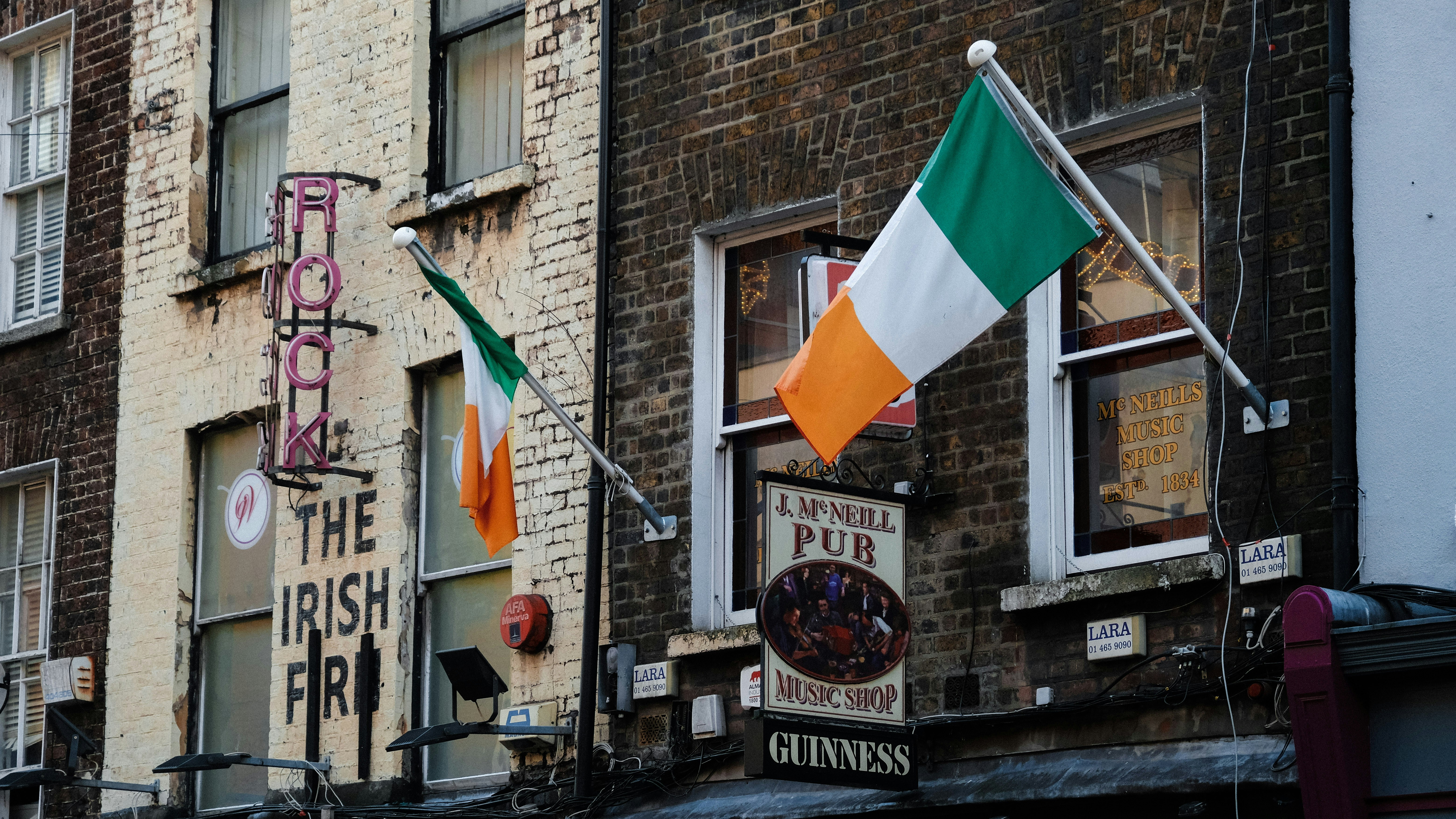 a brick building with irish flags hanging from it's windows