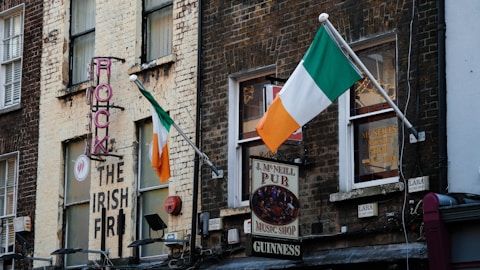 a brick building with irish flags hanging from it's windows