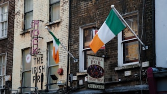 a brick building with irish flags hanging from it's windows