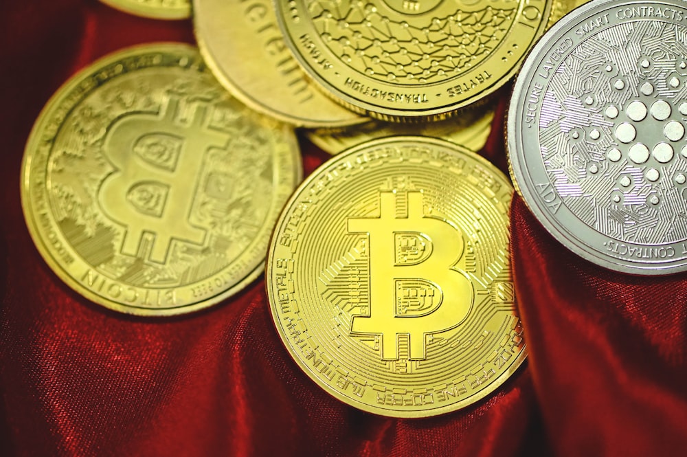 a pile of bitcoins sitting on top of a red cloth