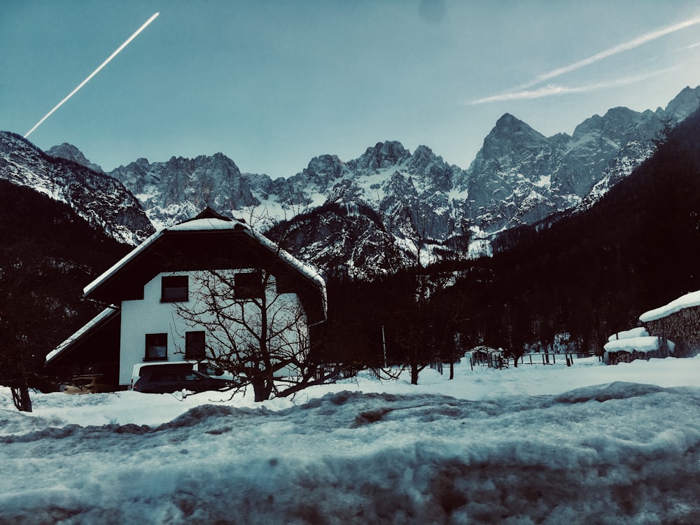 a house in the mountains covered in snow