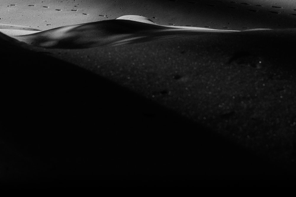 a black and white photo of sand and water