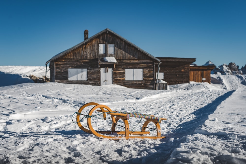 a sled is laying in the snow in front of a house