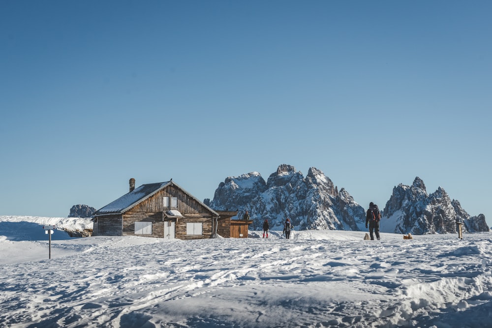 a person standing in the snow in front of a house