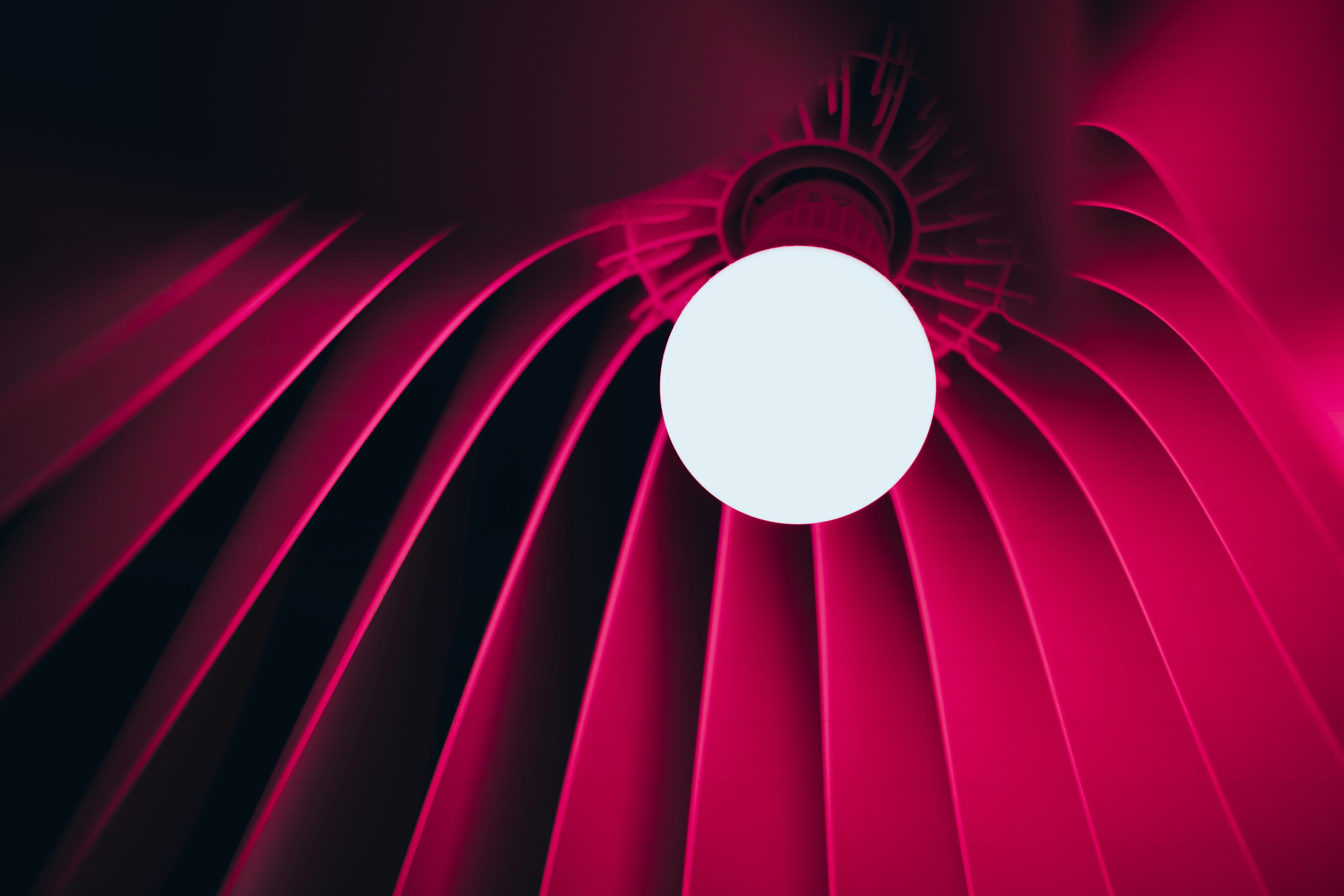 a close up of a red fan with a white ball on it