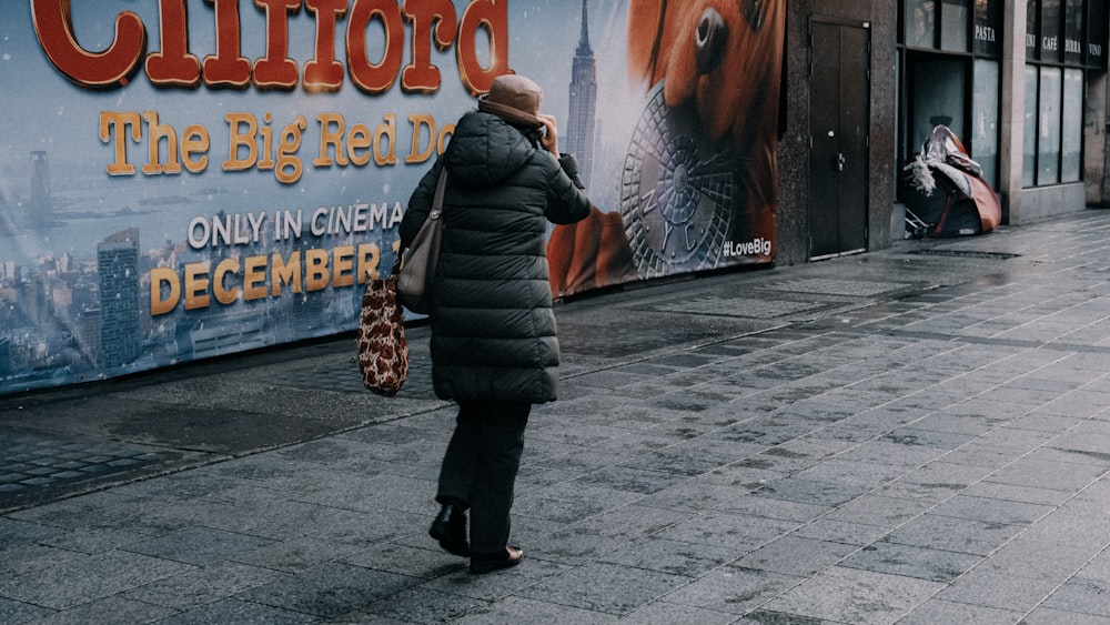 a woman standing on a sidewalk talking on a cell phone