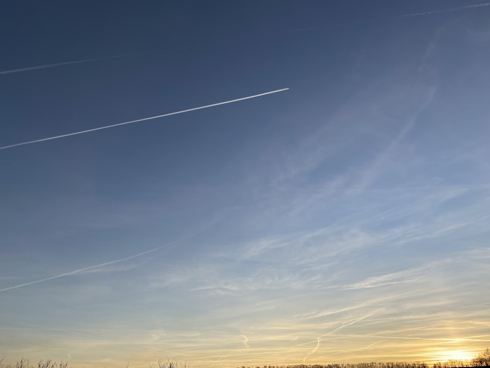 Un avion vole dans le ciel au-dessus d’un champ