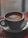 A steaming cup of coffee on a wooden table with soft morning light.