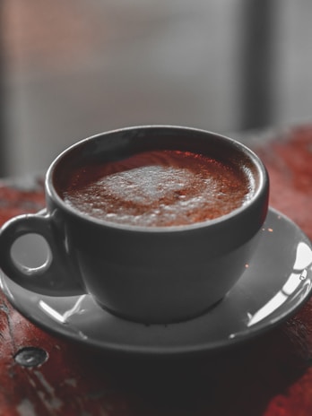 A warm cup of slimming coffee steaming gently on a cream-colored ceramic saucer.