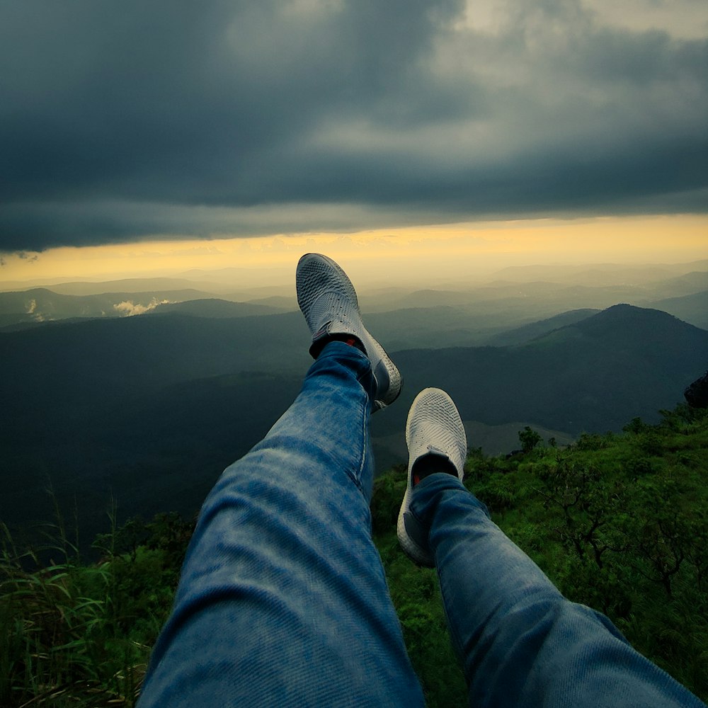 a person standing on top of a lush green hillside