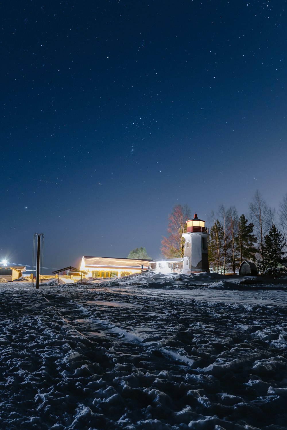 a lighthouse in the middle of a snowy field