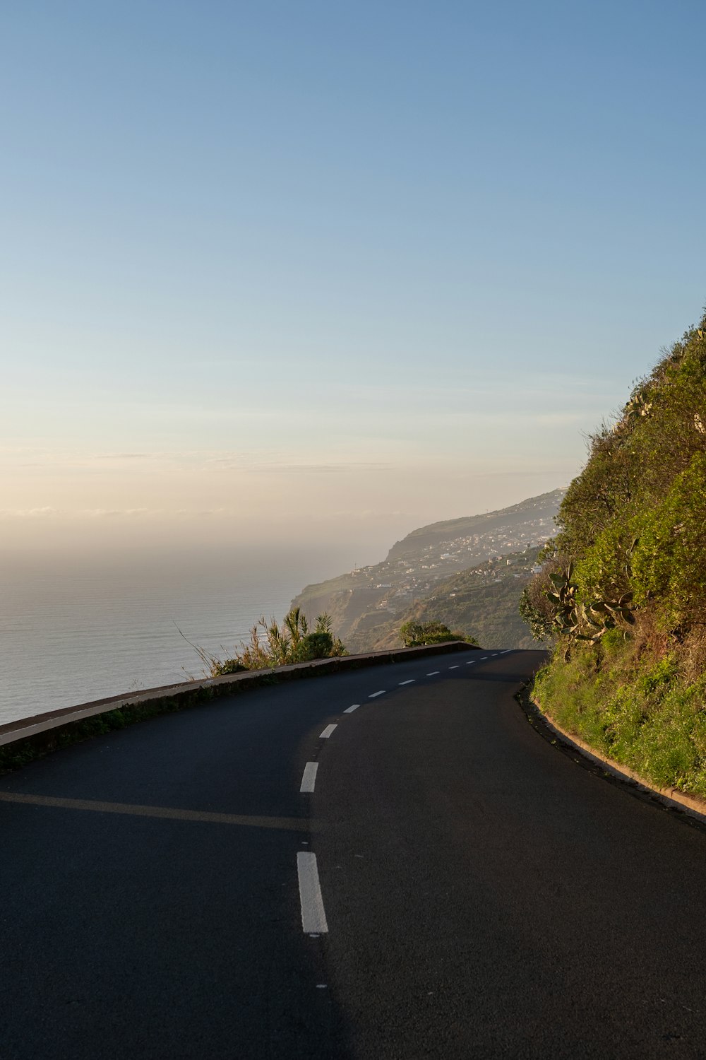 a curved road with a view of the ocean