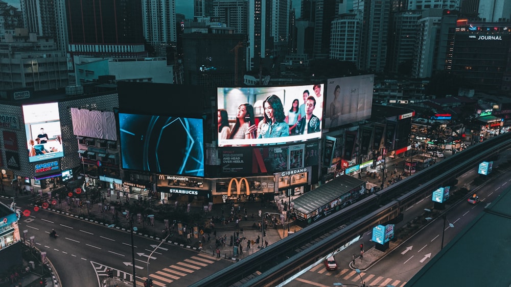 a busy city street at night with billboards