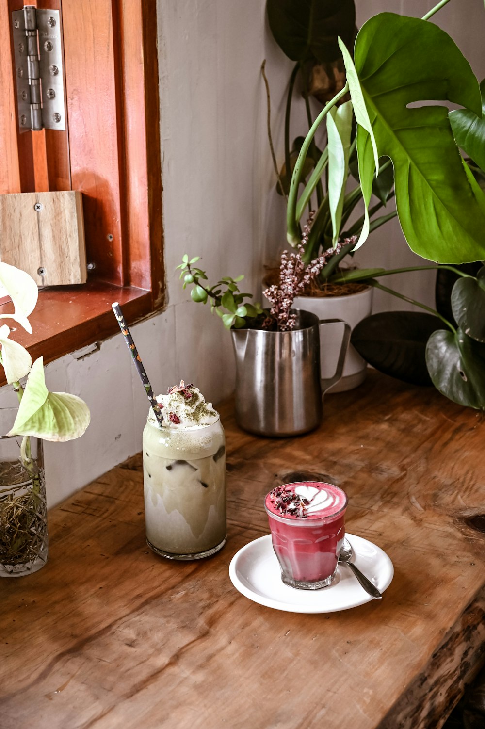 a wooden table topped with two cups filled with drinks