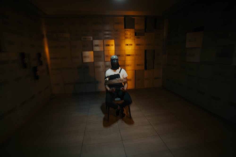 a person sitting on a chair in a dimly lit room