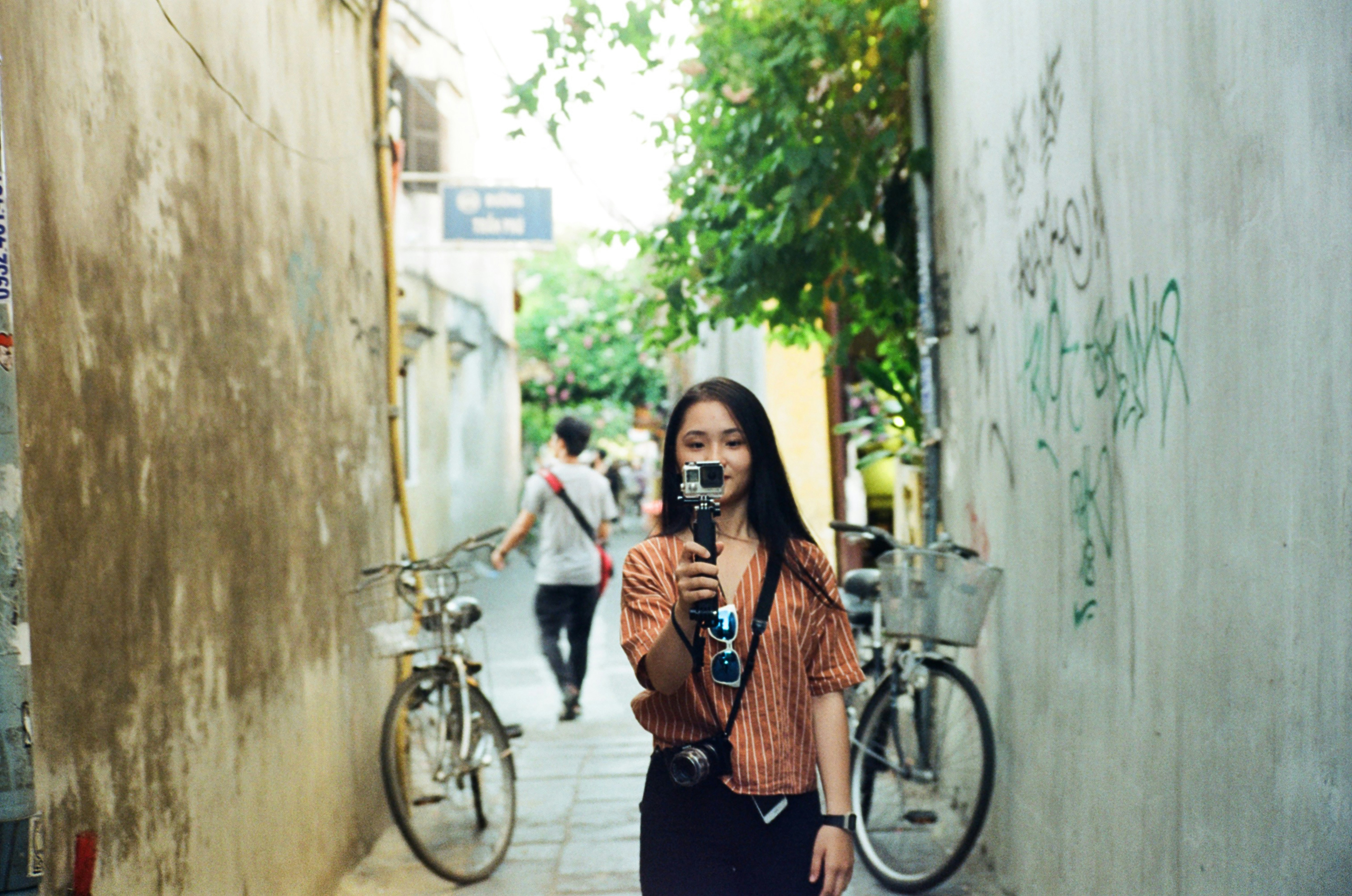 A woman taking a picture of herself in a narrow alley photo – Free ...