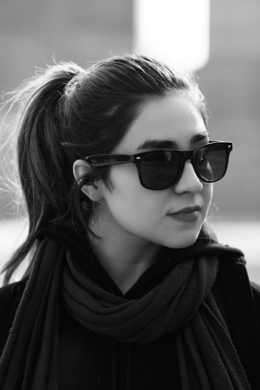 a woman wearing sunglasses and a scarf