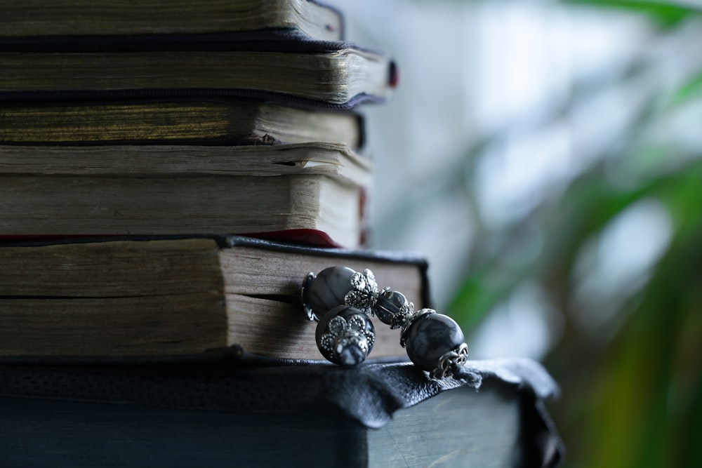 a stack of books with a skull ring on top of it