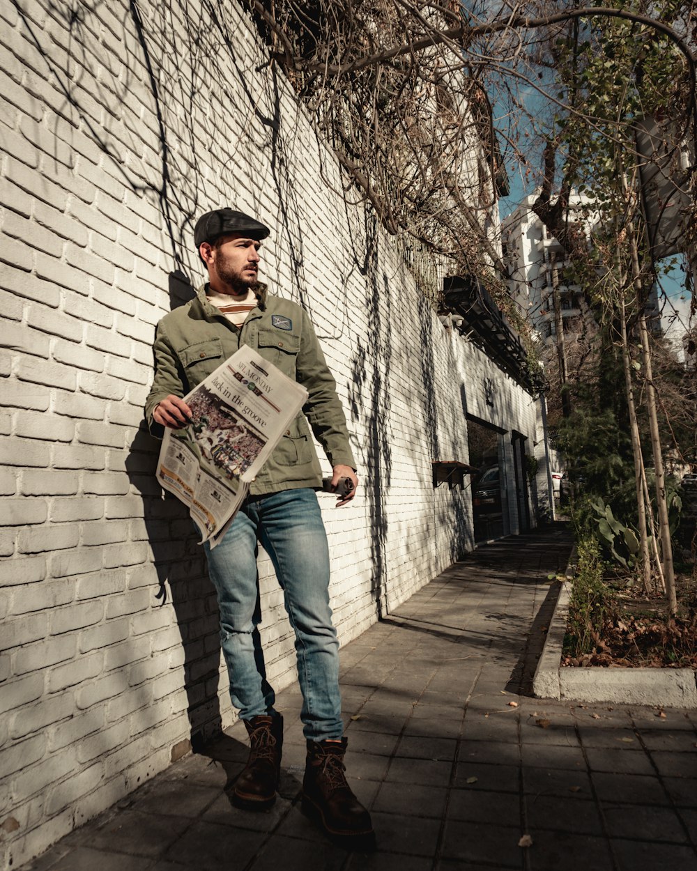 a man standing next to a white brick wall