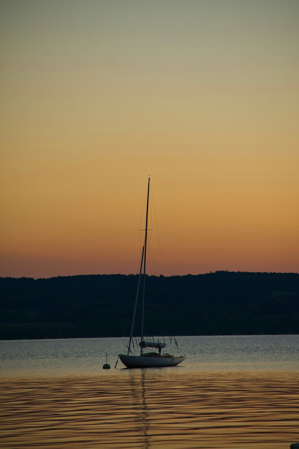 ein Segelboot, das auf einem Gewässer schwimmt