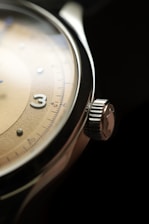 a close up of a watch on a black surface