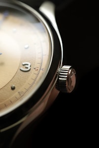 a close up of a watch on a black surface