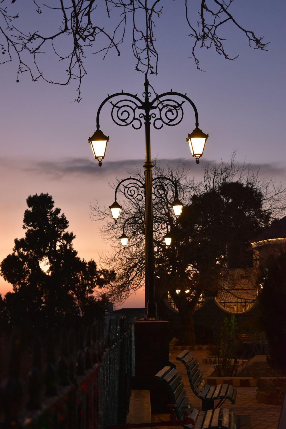 a couple of benches sitting under a street light