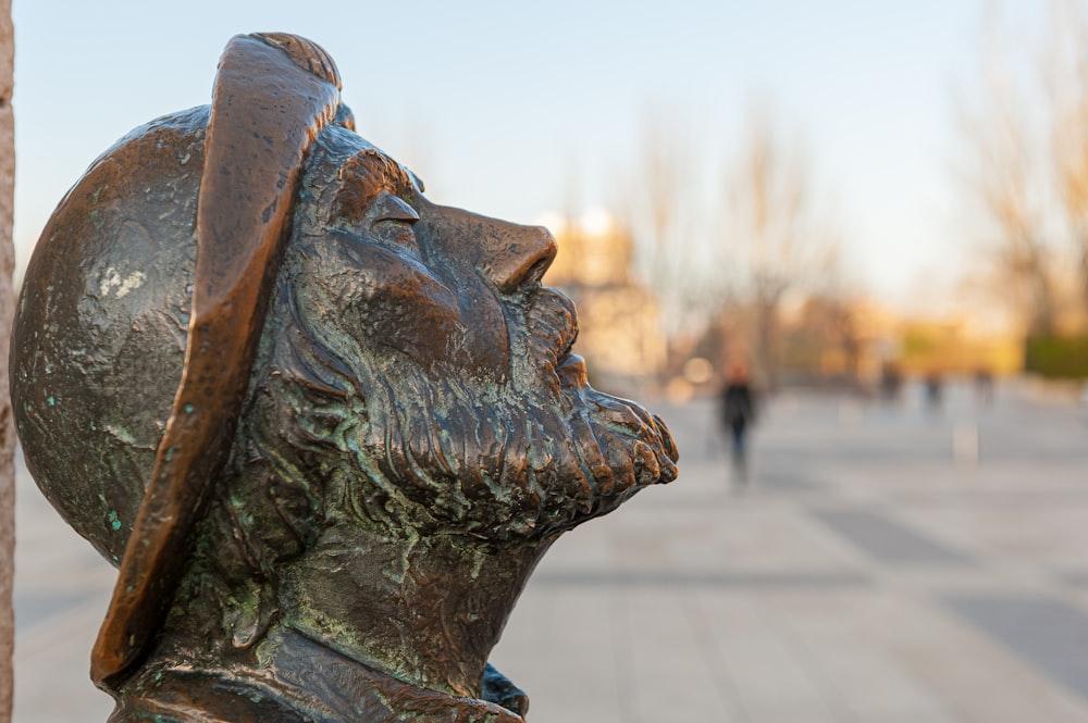 Una estatua de bronce de un hombre con un sombrero en la cabeza