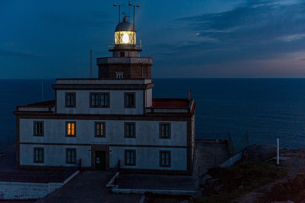 a lighthouse on top of a building near the ocean
