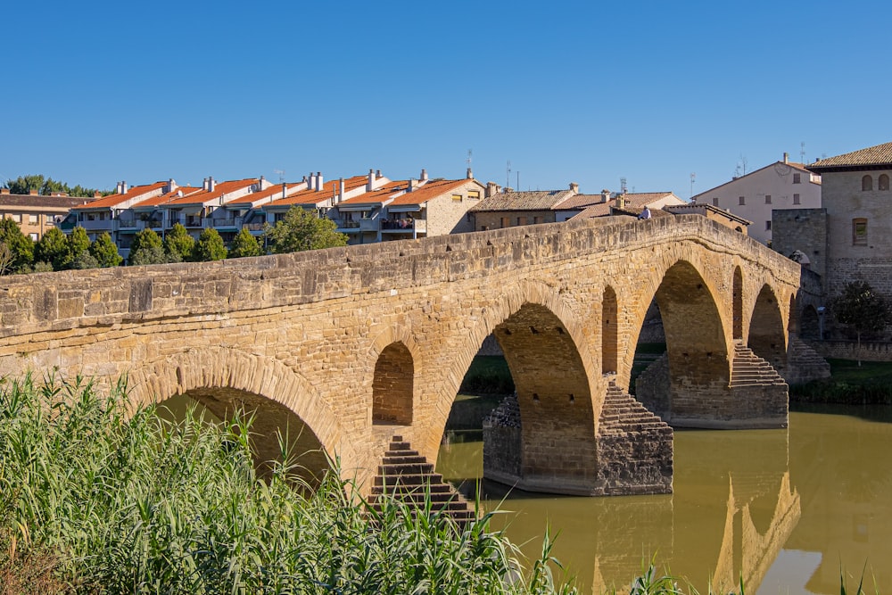 a stone bridge over a river with buildings in the background