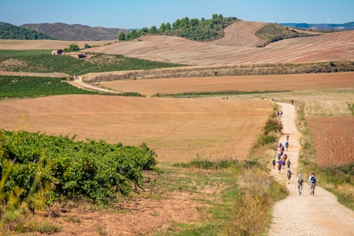 a group of people riding bikes down a dirt road