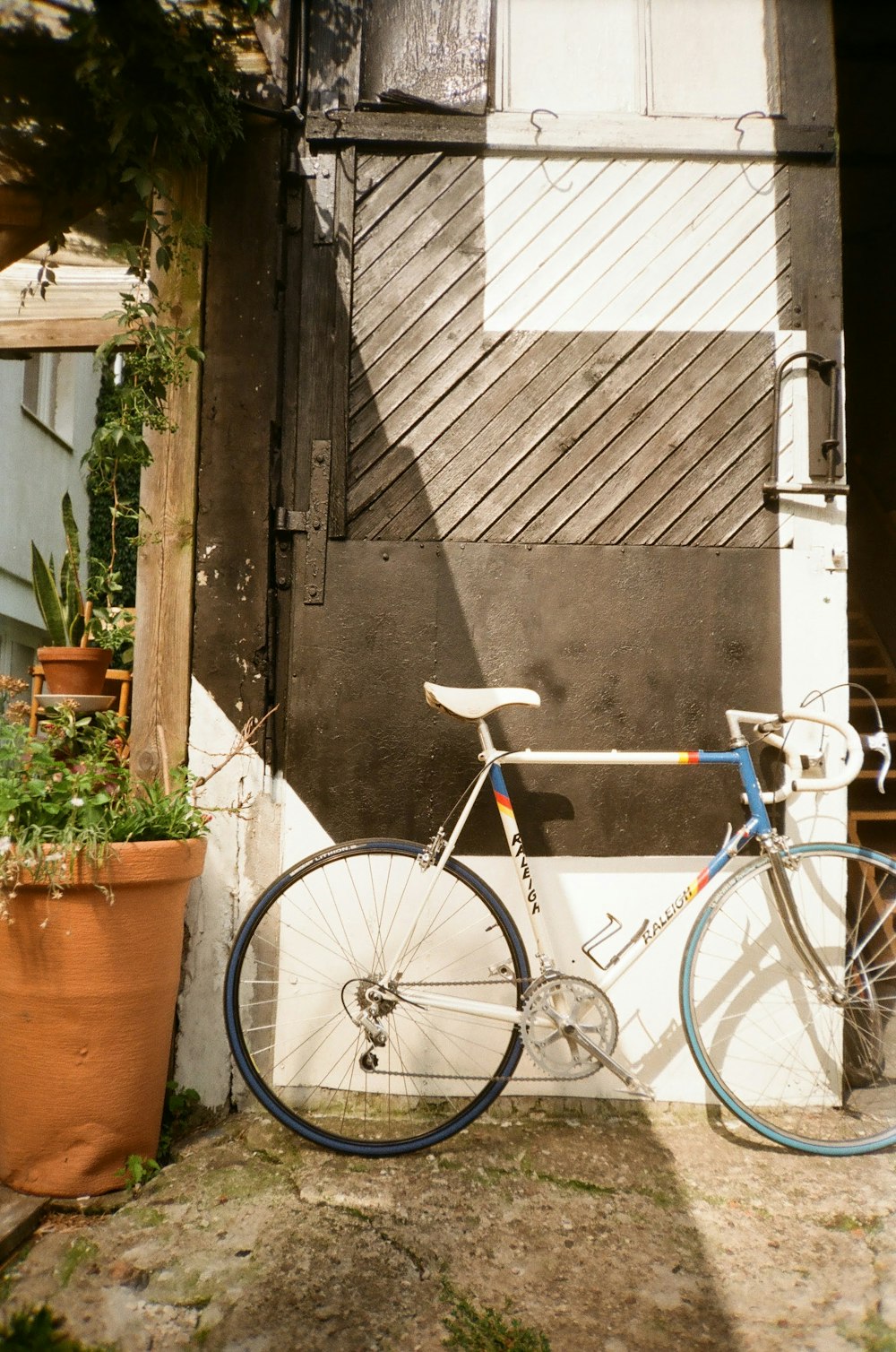 a blue and white bicycle parked next to a building