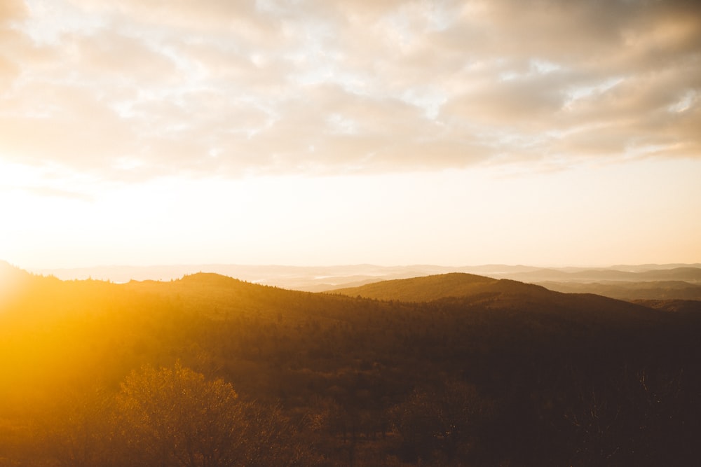 the sun is setting over a mountain range