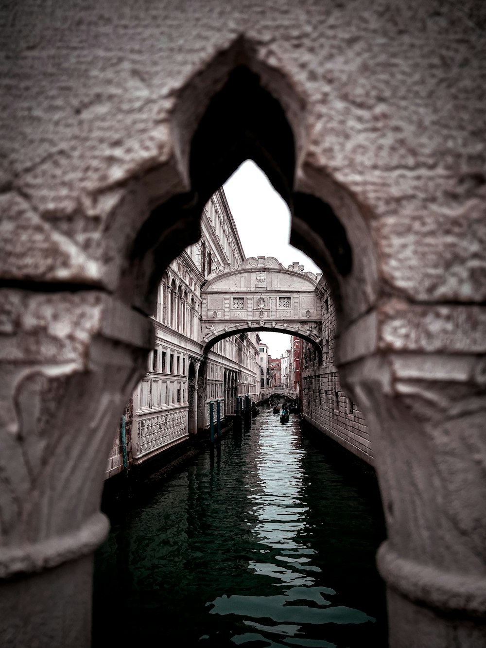 a narrow canal with a bridge in the background