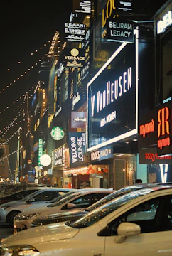 Brightly lit storefront sign glowing at night in a busy urban street.