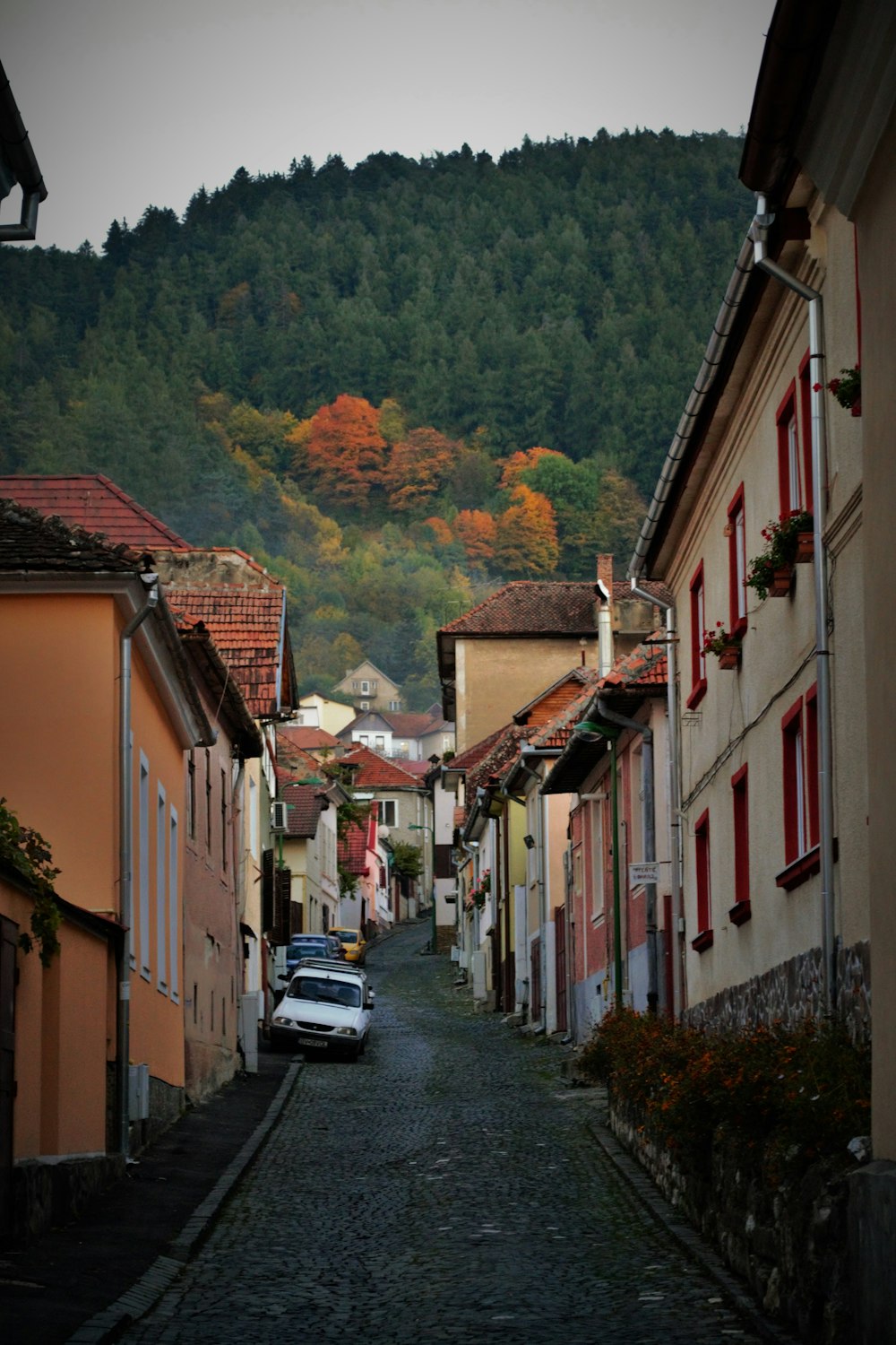 a car is parked on a cobblestone street