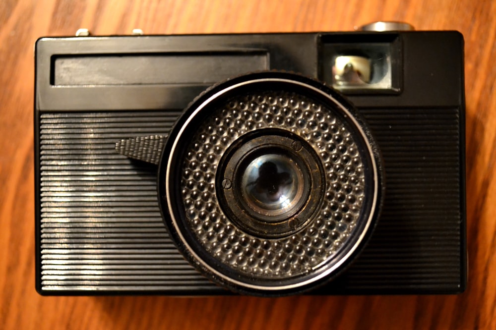 a close up of a camera on a wooden surface