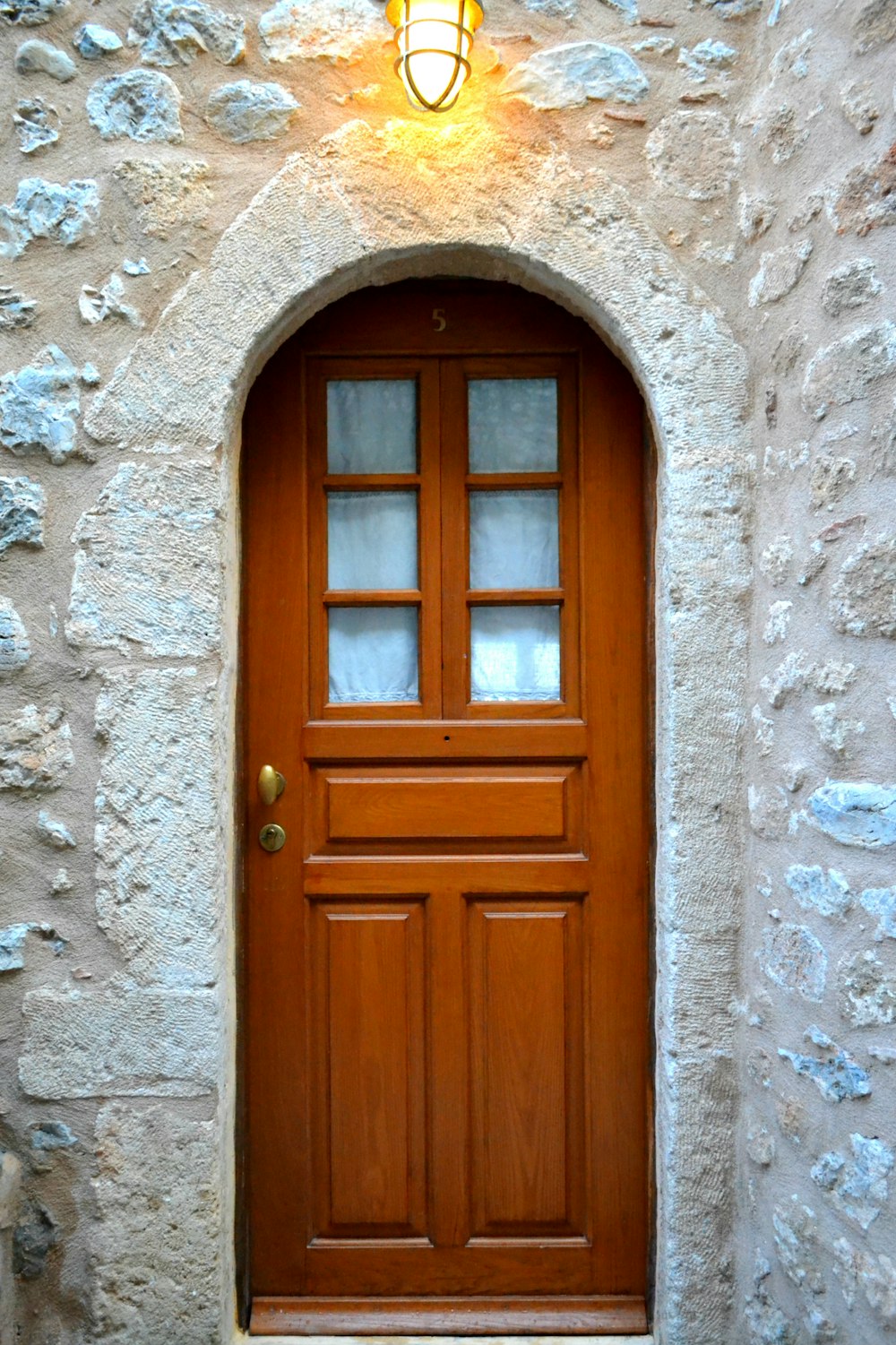 a wooden door with a light above it