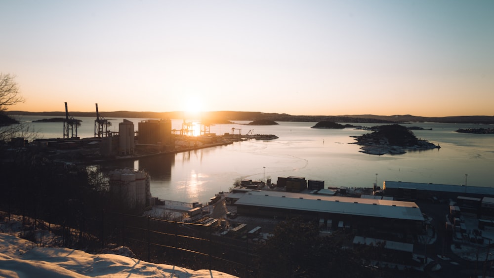 the sun is setting over a harbor in the snow