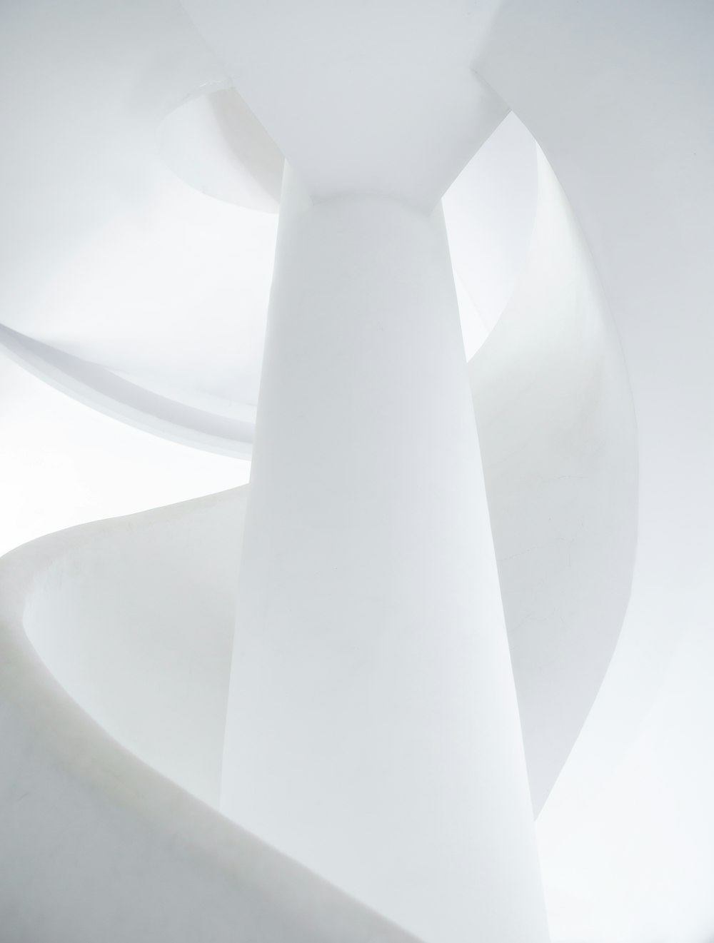 a white sculpture with a spiral design on it