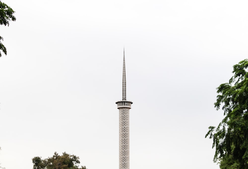 a tall white tower with a clock on it's side